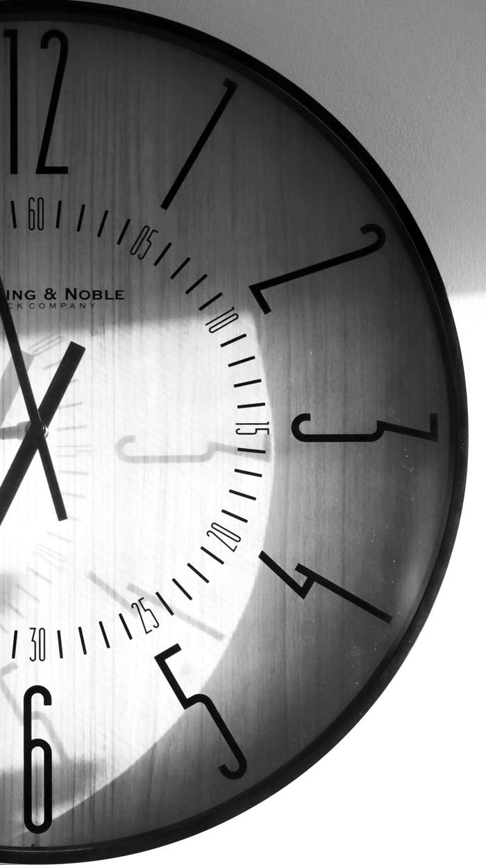 Monochrome clock with shadow play, captured in Ottawa, showcasing timeless elegance.